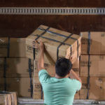 A worker handling stacked boxes of books for delivery to Culion, Palawan