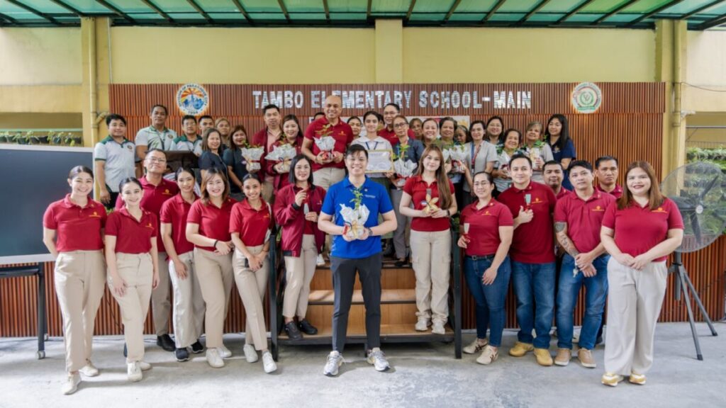 Grand Westside Manila Bay volunteers and school staff in a group photo inside the school hall
